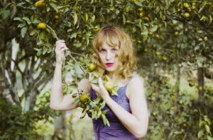blondynka przy drzewie pomarańczy